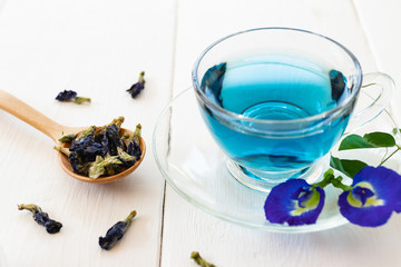 Cup of Butterfly pea flower tea on white wooden background. Health drink concept.