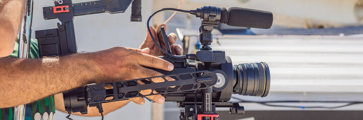 Steadicam operator prepare camera and 3-axis stabilizer-gimbal for a commercial shoot BANNER, LONG...