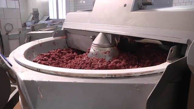 Processing lard or meat in minced meat on a huge meat grinder at a meat factory closeup. KUTTER FOR MEAT. Fine grinding of soft meat raw materials. Meat processing equipment. 