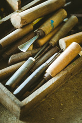 A close up shot of chisels on a board in a workshop