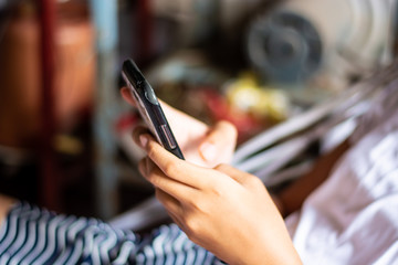 Girl lying in a crib hand holding smartphone  playing social games.