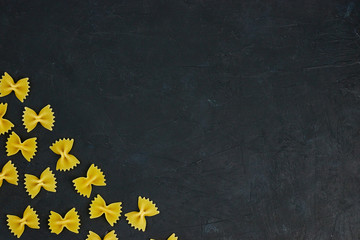 Uncooked pasta, tied with a rope on the concrete on a black background. copy space. view from above. composition of Italian pasta.