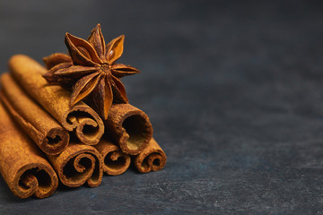 Obraz na płótnie Canvas cinnamon sticks and cardamom on a black background horizontal view close-up with copy space for text. fragrant spices.