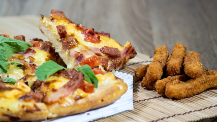 Pizza and the fried nuggets Placed in a pad made of wood Prepare for this dinner.