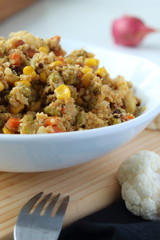 Cauliflower rice with vegetables (peas, corn, onion and carrot). Vertical image.