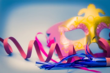 Carnival mask, streamers and confetti on bright blue background