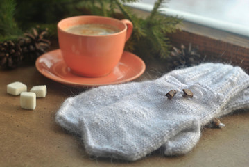 Hot coffee in a pink ceramic cup, sugar, fir branches, warm mittens and a winter snow window. Christmas or New Year card.