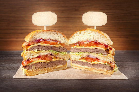 Halves hamburger with fried meat and vegetables on wrapping paper. Space for text