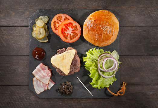 Ingredients for a hamburger on a slate board. top view