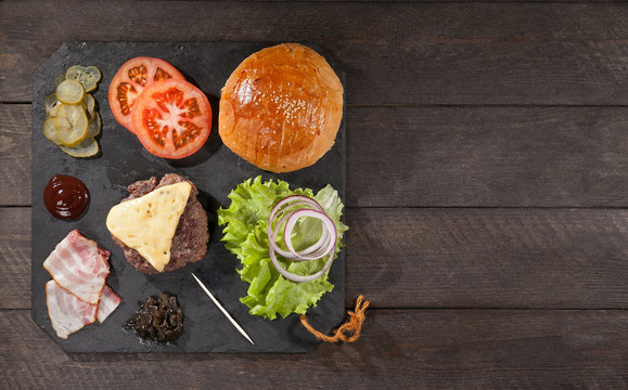 Ingredients for a hamburger on a slate board. top view