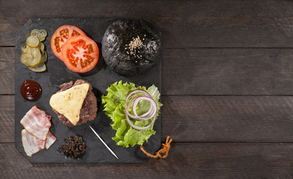 Ingredients for a hamburger on a slate board. top view