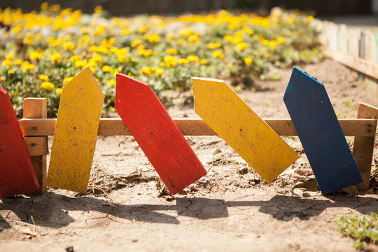 Multi-colored small fence around the flowerbed. Close-up