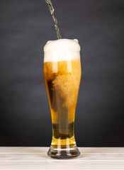 Pour beer in a glass with black background