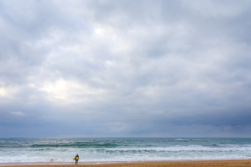 Fototapeta na wymiar Atlantic ocean evening surfer with yellow board 1