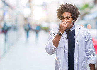 Afro american doctor scientist man over isolated background looking stressed and nervous with hands on mouth biting nails. Anxiety problem.
