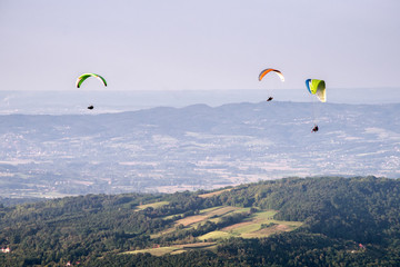 Paragliding at stunning mountain scenery with green pastures and forests