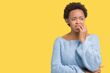Young beautiful african american woman wearing a sweater over isolated background looking stressed and nervous with hands on mouth biting nails. Anxiety problem.