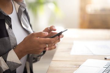Close up of African American girl holding smartphone chatting or texting friends, black female...