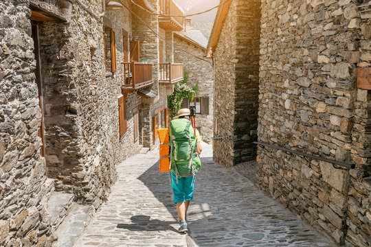 Pilgrim Woman hiker on a route trail across the old medieval town or village