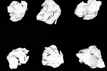 crumpled sheets of paper on a black background
