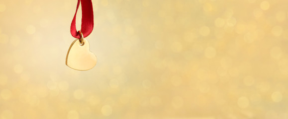 Golden heart against defocused background as valentines card