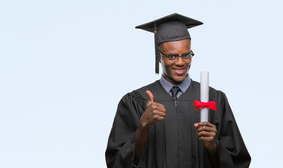Young graduated african american man holding degree over isolated background happy with big smile doing ok sign, thumb up with fingers, excellent sign