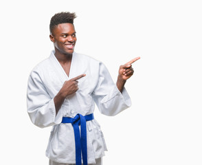 Young african american man over isolated background wearing kimono smiling and looking at the camera pointing with two hands and fingers to the side.