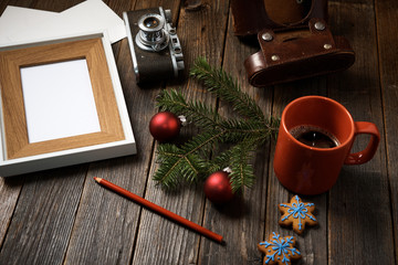 Photos, camera, pine tree branch and cup of coffee.