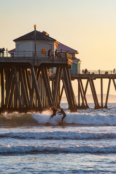 Surfer collision near the pier at sunset on Huntington beach pier in southern California