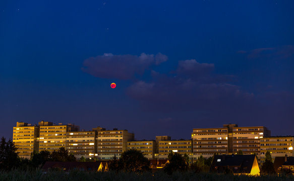 Rodgau, Germany, 2018-07-27 22:26 - Blood moon over cityscape at the blue hour.