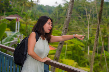 Naklejka premium lifestyle outdoors portrait of young beautiful and happy Asian Korean backpacker woman enjoying holidays at tropical rice terrace smiling delighted in Asia travel