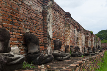 Fototapeta na wymiar The old temple wall and ruins of the Buddha image. Ayutthaya Historical Park. world heritage of UNESCO, Thailand
