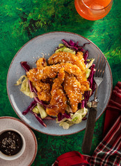 Salad with warm glazing chicken, sprinkled with sesame seeds. Chinese cuisine. Asian culture
