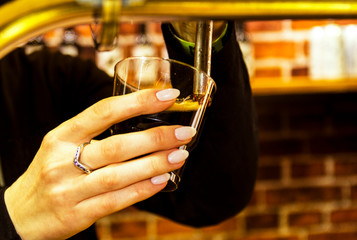 girl pours beer into a glass