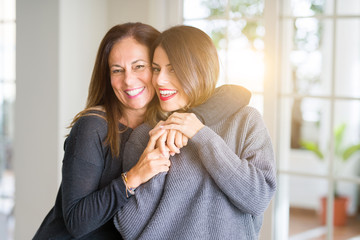 Beautiful family of mother and daughter together, hugging and kissing at home