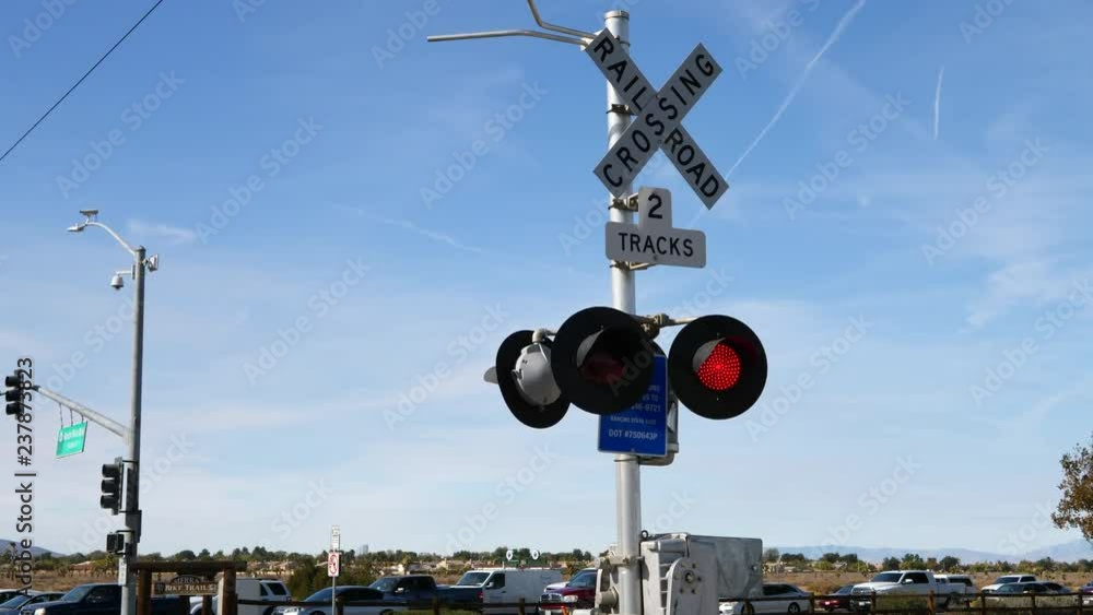 Poster a railroad crossing signal flashing a red light and holding a barrier to prevent traffic while a tra