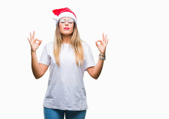 Obraz na płótnie Canvas Young beautiful woman wearing christmas hat over isolated background relax and smiling with eyes closed doing meditation gesture with fingers. Yoga concept.