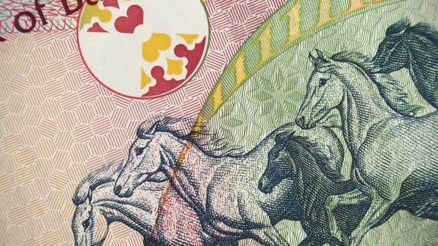 Galloping Arabian Horses on Bahrain one dinar (2006) banknote rotating, Bahraini money close up. 4K UHD video footage.