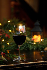 red wine in a glass on the background of garlands, Christmas trees and decorations. Christmas
