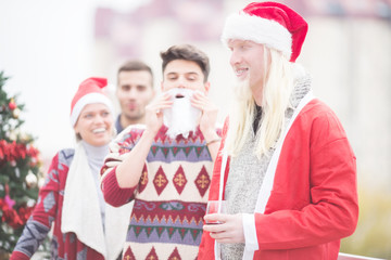 Obraz premium Young man as Santa with friends