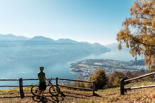 Mountainbiker blickt vom Berg Cimetta &uuml;ber Locarno, Ascona und den Lago Maggiore, Tessin, Schweiz.