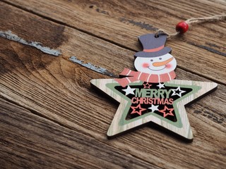 Merry christmas text and Star decorations with Snowman on the old wood board by Flat lay, top view and copy space. In concept, happy with the holidays in the new year.