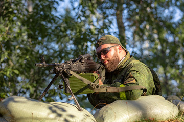 Sniper armed with large caliber, sniper rifle, shooting enemy targets on range from shelter,...