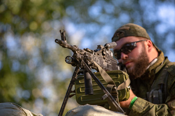 Sniper armed with large caliber, sniper rifle, shooting enemy targets on range from shelter,...