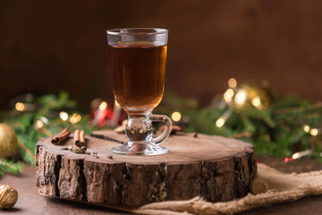 Cup of tea with oragne  and golden candle light near Christmas tree. Spirit of Christmas