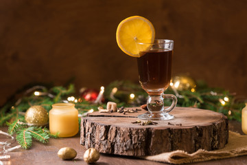Cup of tea with oragne  and golden candle light near Christmas tree. Spirit of Christmas