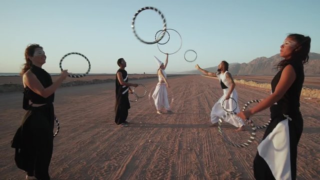 People make ring juggling show in desert at sunset shaky footage slow motion