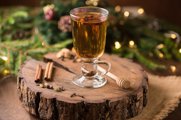 Spiced Apple Cider Mulled Sangria in glass cup on wooden background. Hot drinks for Christmas.