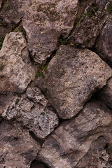base stone block weathered gray beige sloping cobblestone rock mountain part of the gorge wall close-up background