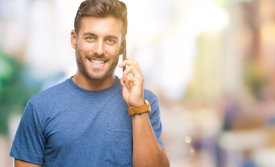 Young handsome man talking on smartphone over isolated background with a happy face standing and smiling with a confident smile showing teeth